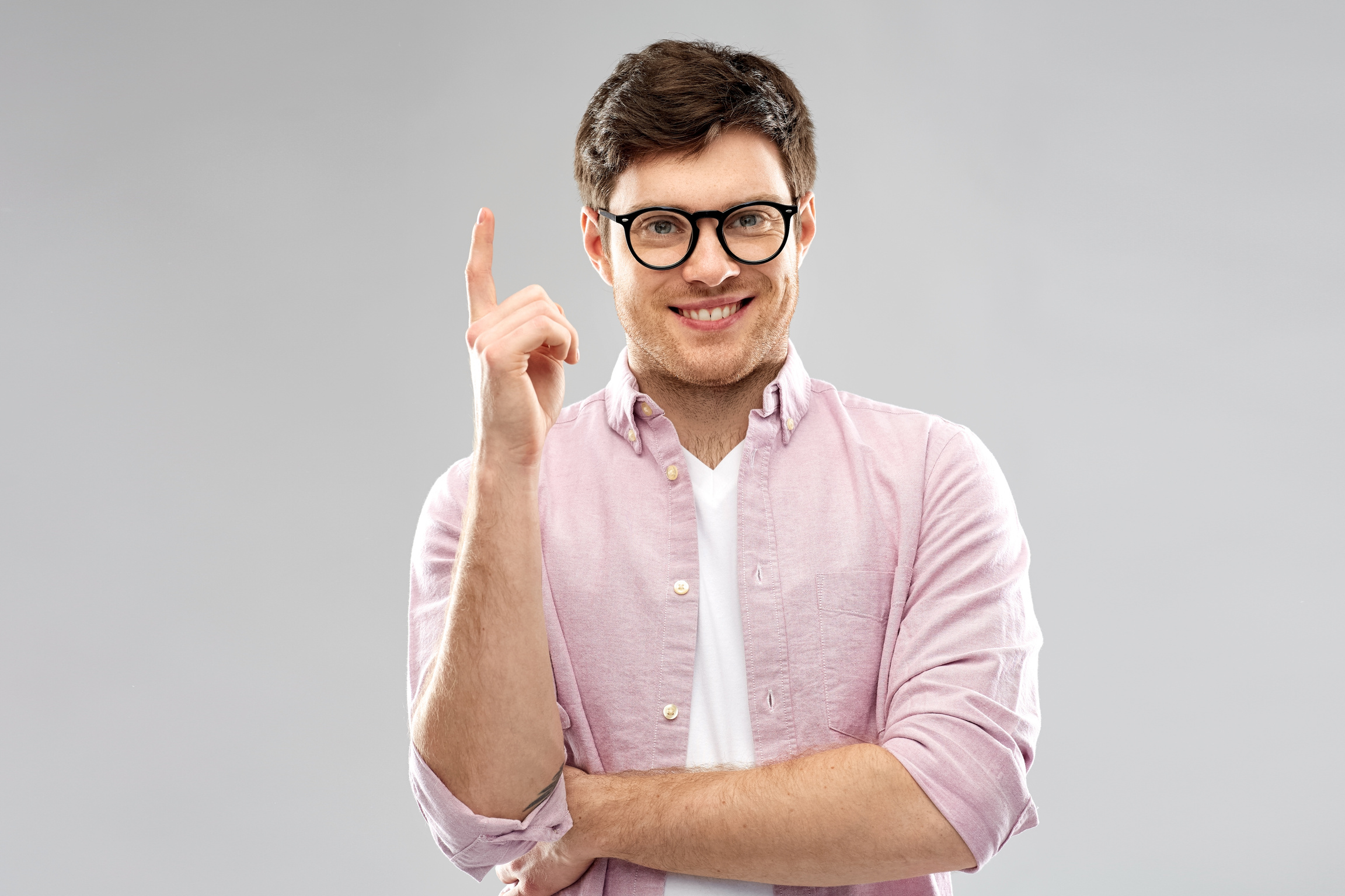 Smiling Young Man in Glasses Pointing Finger up